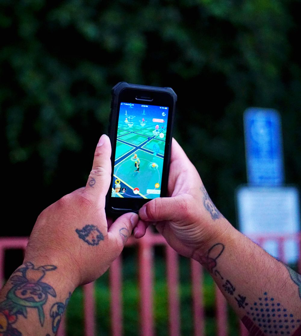 Seseorang bermain game di ponsel sambil duduk santai