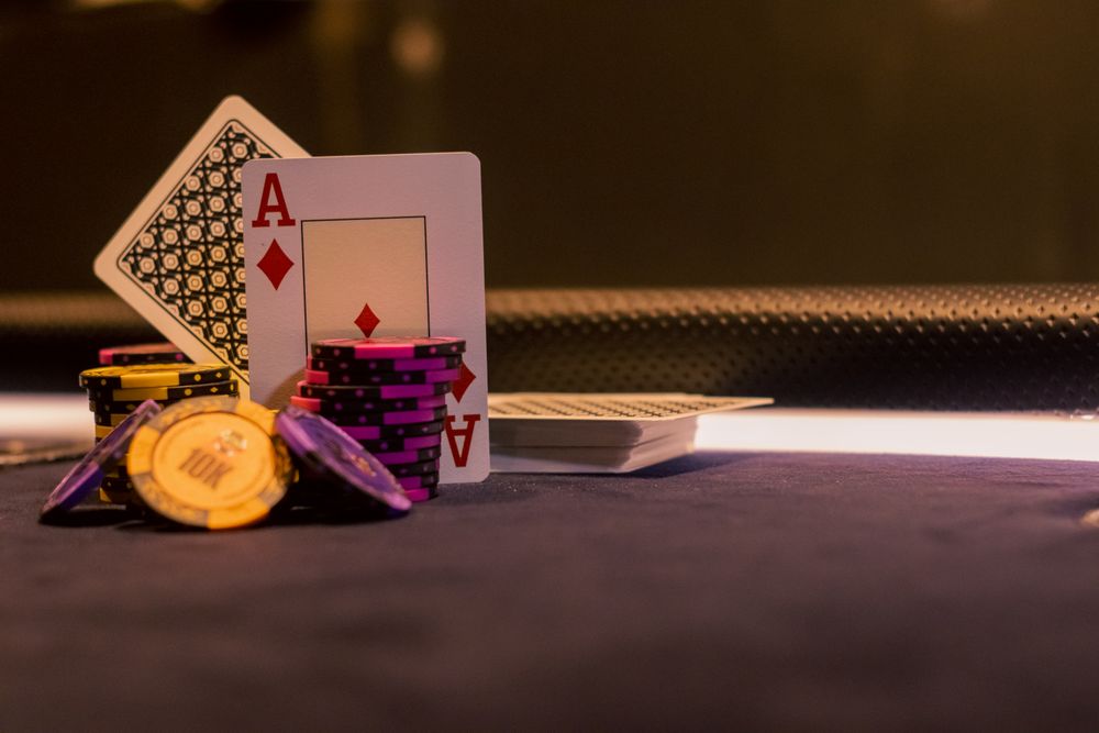 Kartu remi dan chip poker tertata di atas meja permainan