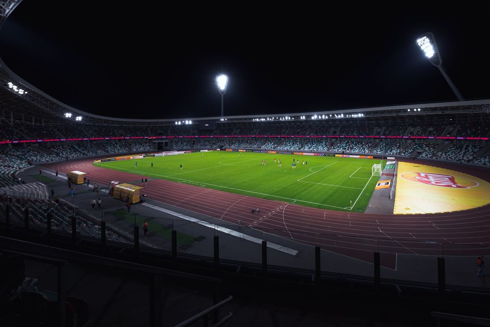 Stadion sepak bola menyala di malam hari saat pertandingan berlangsung